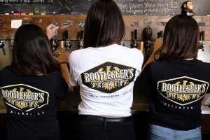 three females pouring beer from the taps
